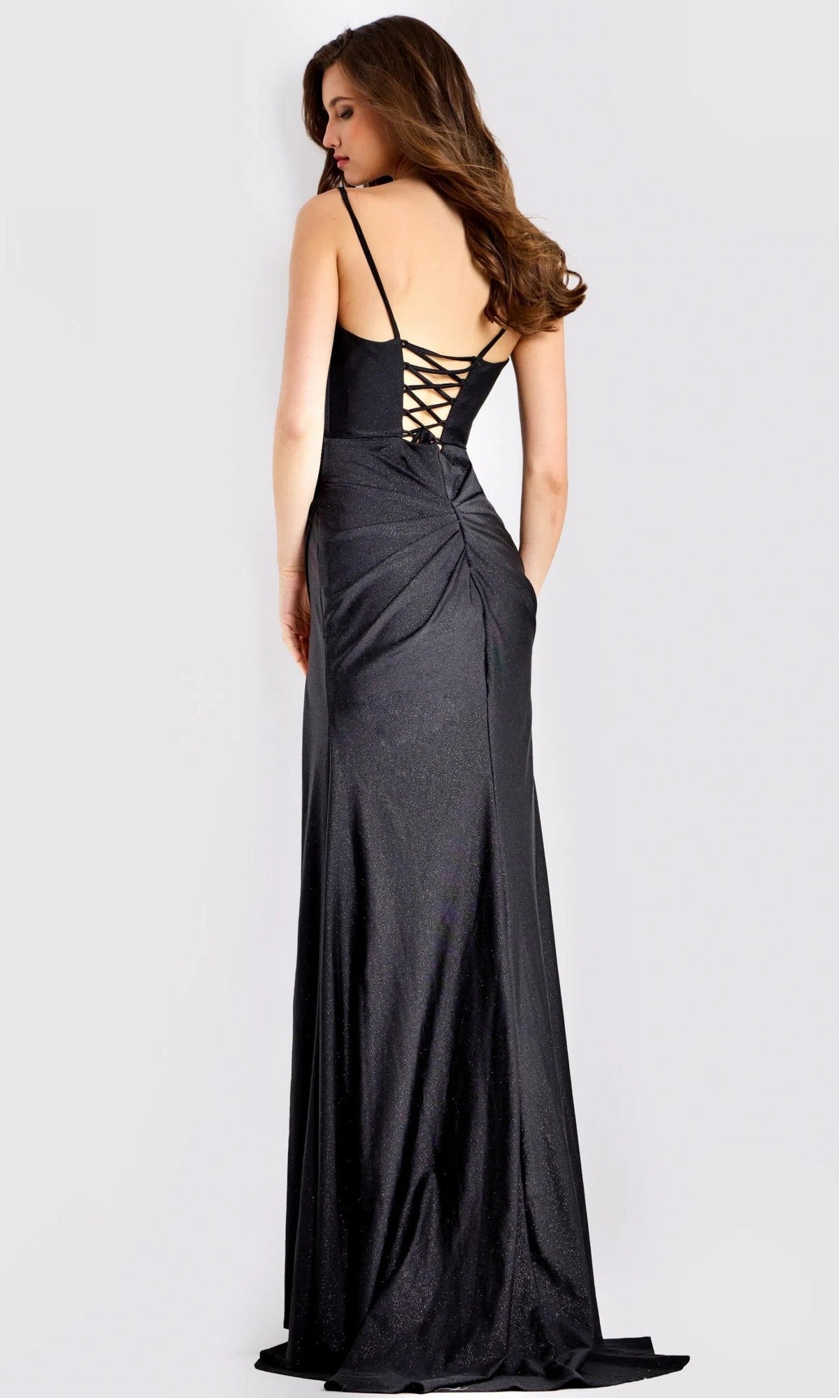 A woman models the Jovani 49616 long prom dress, featuring a black corset bodice, lace-up back, and high-leg slit, standing against a plain light background.
